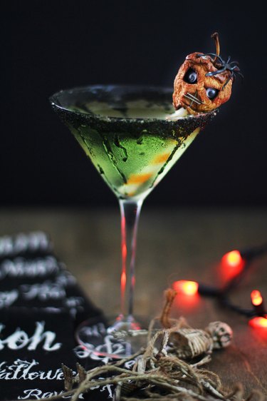 green caramel apple martini garnished with shrunken head