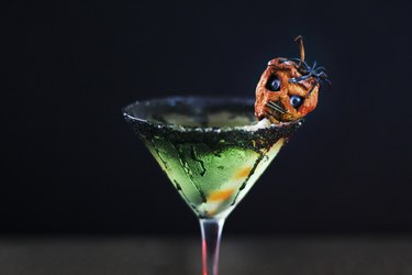 green caramel apple martini garnished with shrunken head