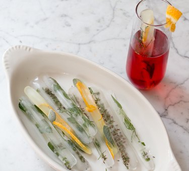 Ice cube swizzle sticks with herbs and orange peel