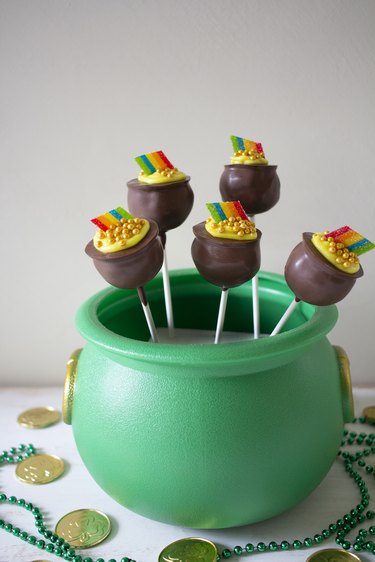 Chocolate pot of gold cake pops displayed in green cauldron