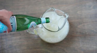 Pouring sparkling water into pitcher