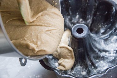 Cake batter being poured into a bundt cake pan