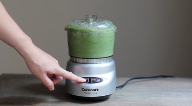 Blending green smoothie in food processor