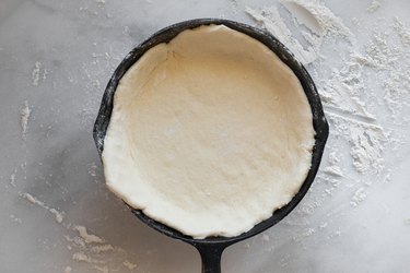 Press half of the dough into the base of the skillet.