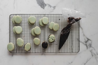 Fill the macarons with the dark chocolate ganache.