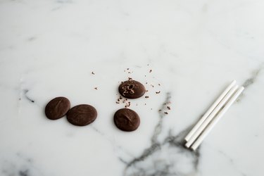 Hollow out the middle of the chocolate buttons so that the cake pop sticks can just fit through them.