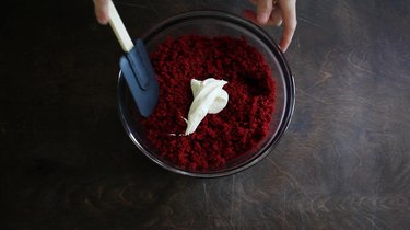 Stirring frosting into cake crumbs