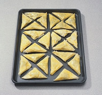 Place phyllo dough triangles down on pan when making pastries.