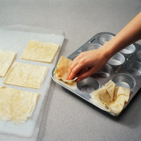 Place squares into greased muffin cup when making phyllo dough blossoms.