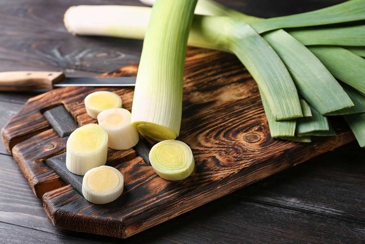 Cut fresh leeks on wooden board