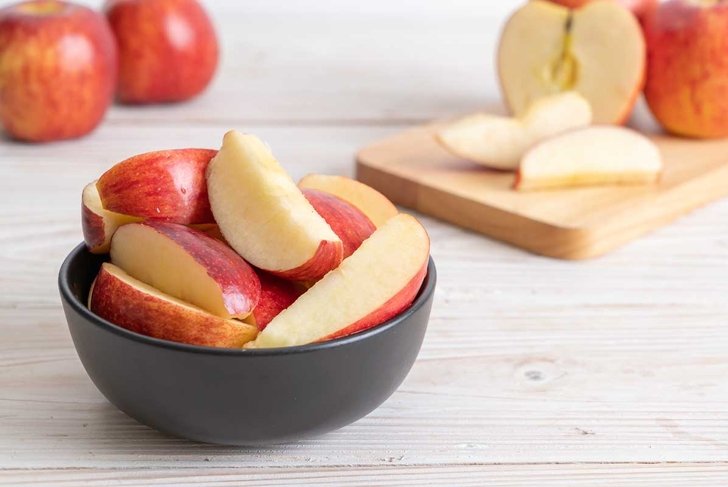 fresh red apples sliced bowl on wood background